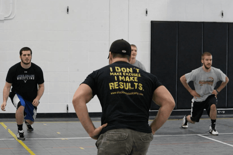 Chad Moeller coaching a group of athletes through lunges in the gym.